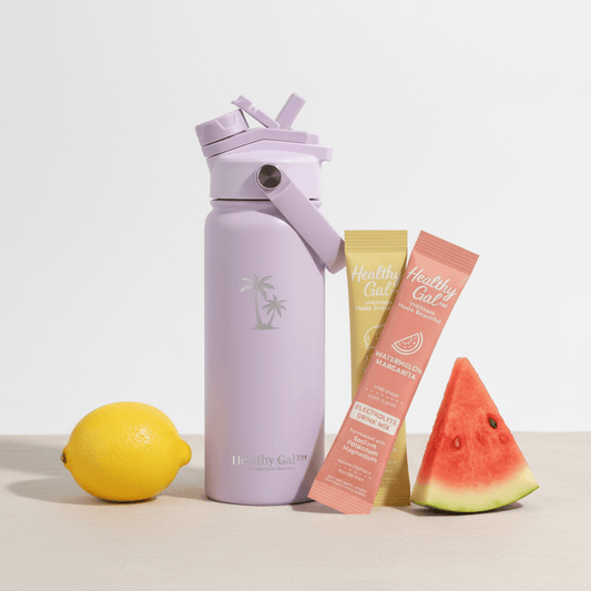 Healthy Gal™ Move Hydration Bottle in lavender with Watermelon Margarita and Lemon Drop electrolyte stick packets, a lemon, and a watermelon slice